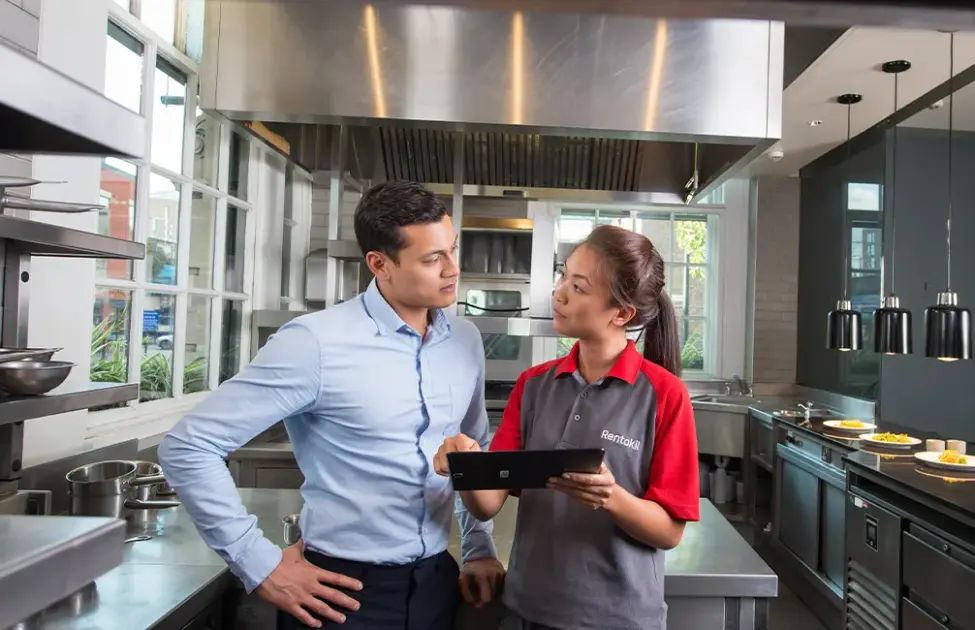 A Rentokil Pest Control Technician shows a restaurant manager a quote for service