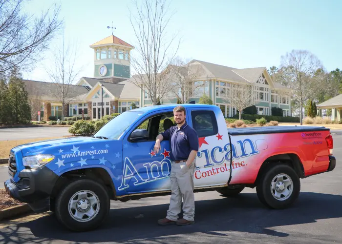 American Pest Control, Inc. technician standing with truck. Protect your business from unwanted pests before it's too late.