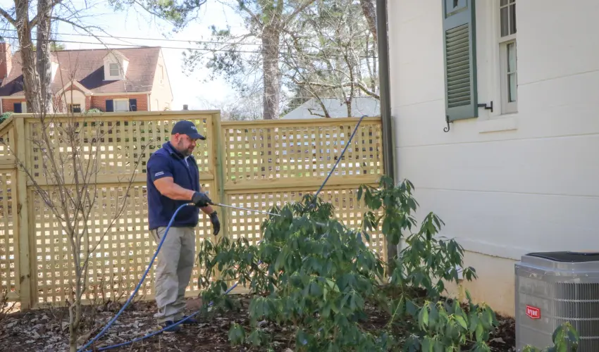 An American Pest Control, Inc. technician sprays Termidor around an Athens, GA home.