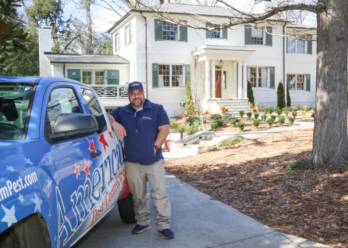 American Pest Control, Inc. technician standing with truck outside an Athens, GA home after pest treatment