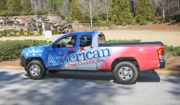 An American Pest Control, Inc. technician driving to a quarterly pest management customer