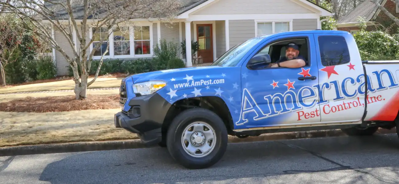 An American Pest Control, Inc. technician in a service truck after implementing protection plan services