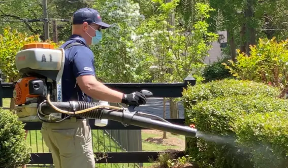 An American Pest Control, Inc. technician applies mosquito treatment to a yard in Franklin, NC