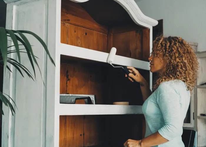 Painting an antique, wooden cabinet. Old furniture is a common place for bed bugs to infest.