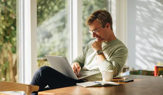 A happy pest control customer using laptop to engage with American Pest Control, Inc.