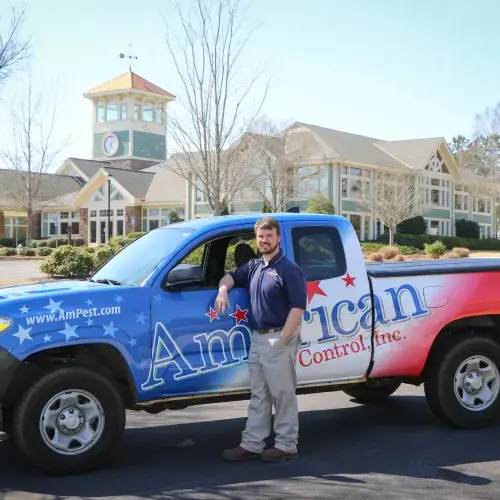 An American Pest Control, Inc. technician stands with service truck after pest application