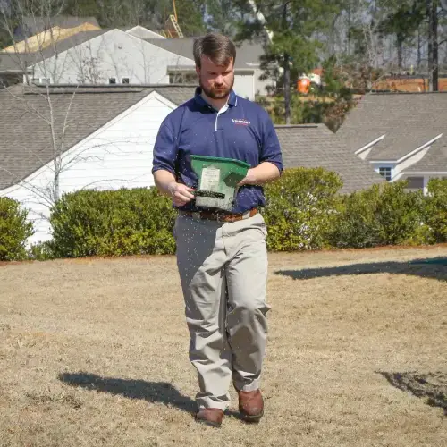 An American Pest Control, Inc. technician applies pest treatment to a lawn
